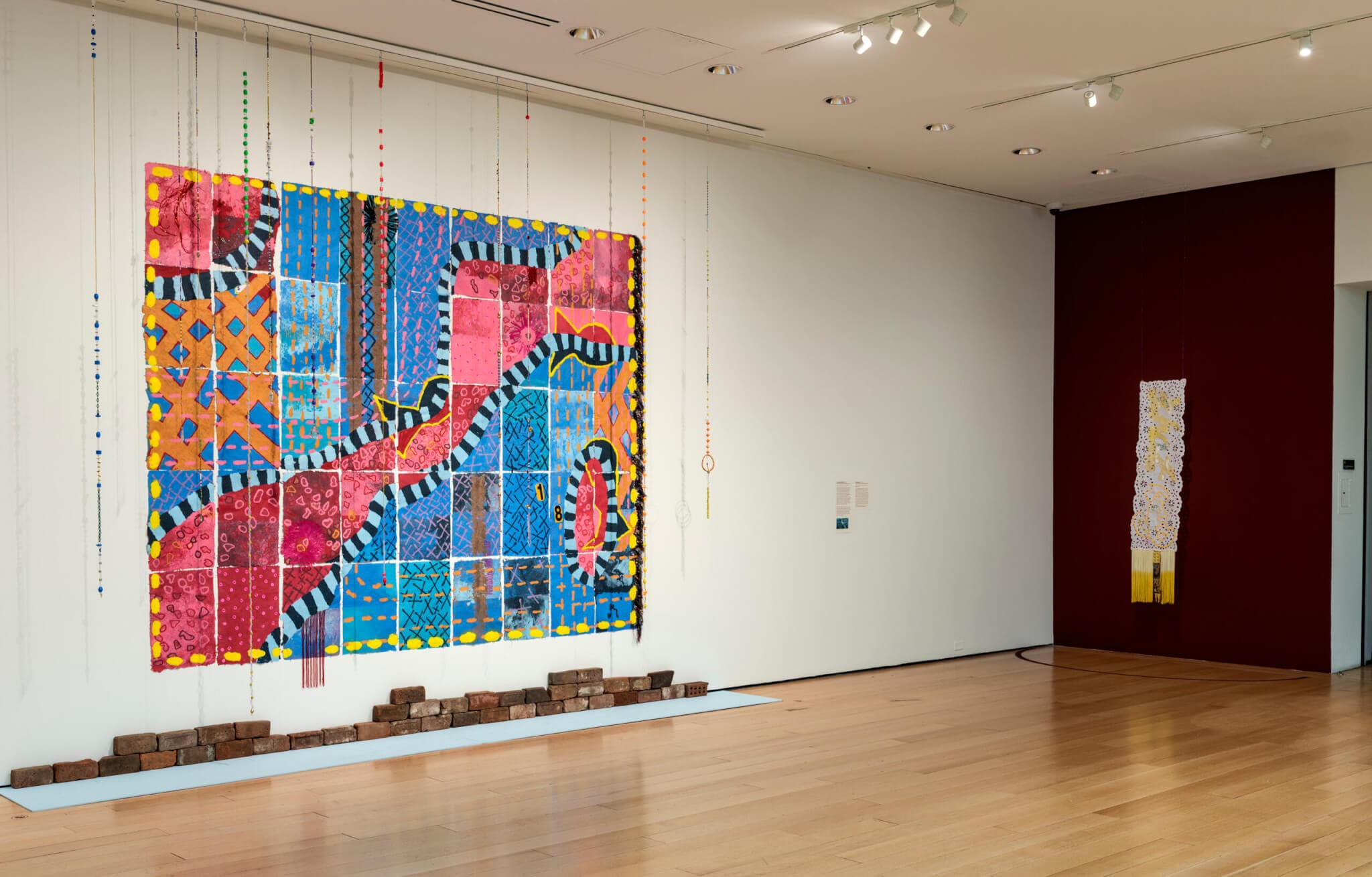 A large, colorful paper work on a gallery wall.